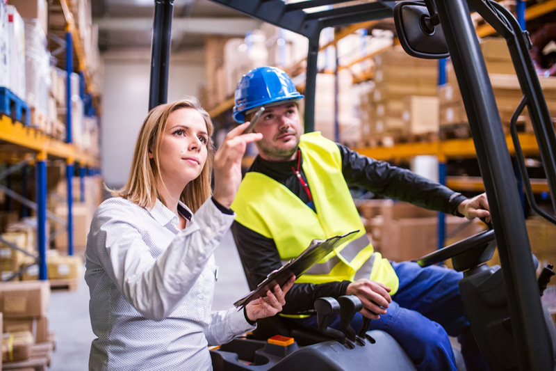 Young warehouse workers working together.