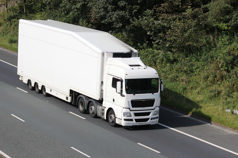 White lorry in the slow lane on a rural three lane motorway.